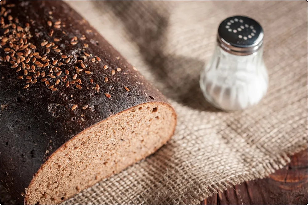 Loaf of bread with a salt shaker on a cloth